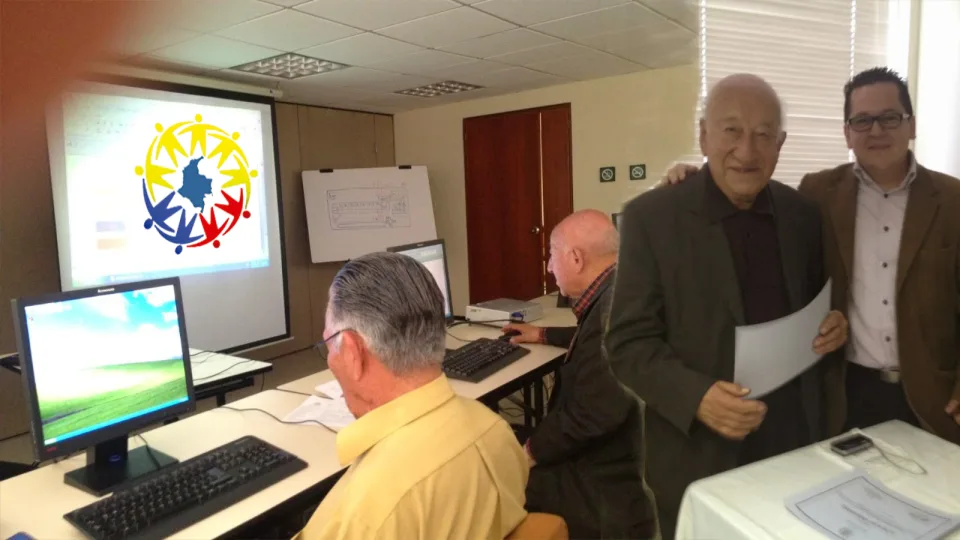 Pareja de personas mayores sonriendo mientras aprenden a usar un computador portátil en su sala