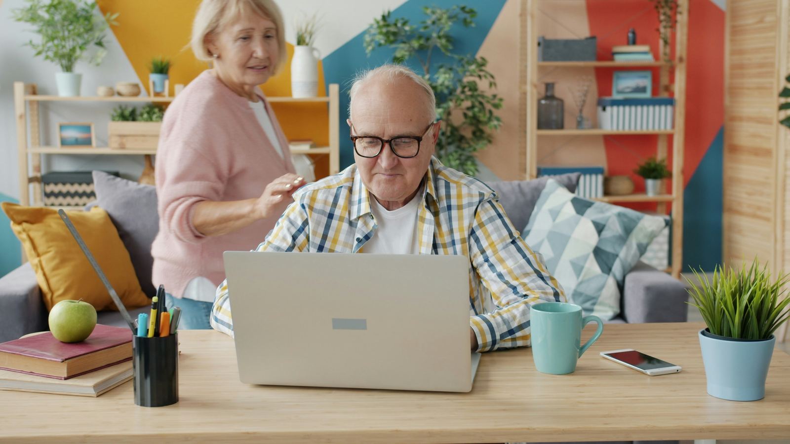 Hombre mayor concentrado escribiendo en su computador portátil